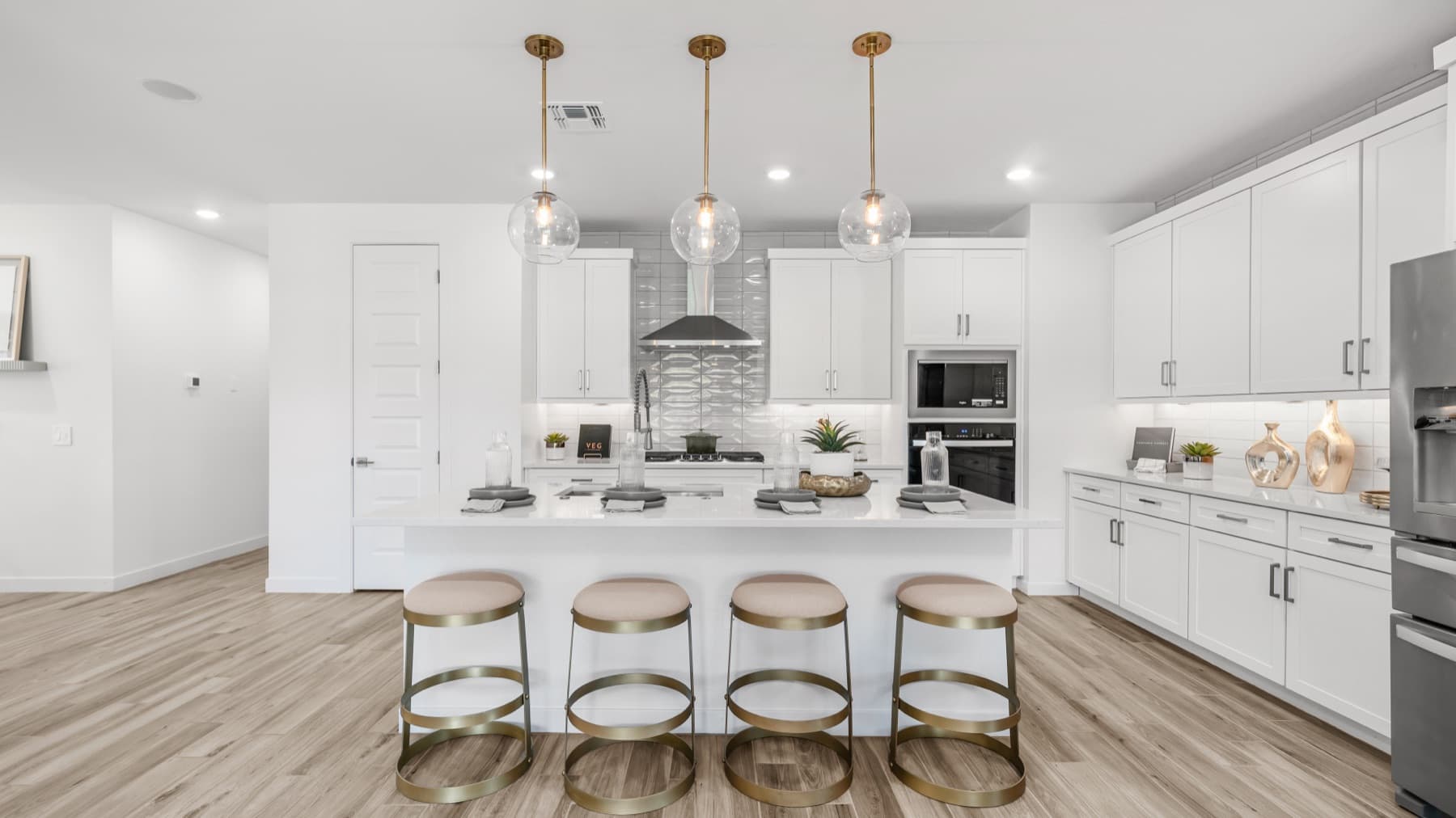 Bright new-build kitchen with white cabinetry and brass pendant lights